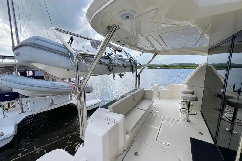 Slide: The Image of Luxurious 2019 Aquila 44 yacht deck with seating, bar stools, and mounted dinghy. - 16