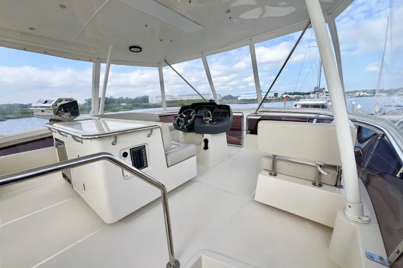Slide: The Image of Flybridge of 2019 Aquila 44 yacht with helm station and seating, overlooking marina. - 19