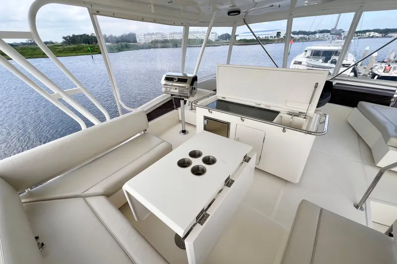 Slide: The Image of Luxurious 2019 Aquila 44 yacht interior with seating, table, and grill overlooking serene waters. - 21
