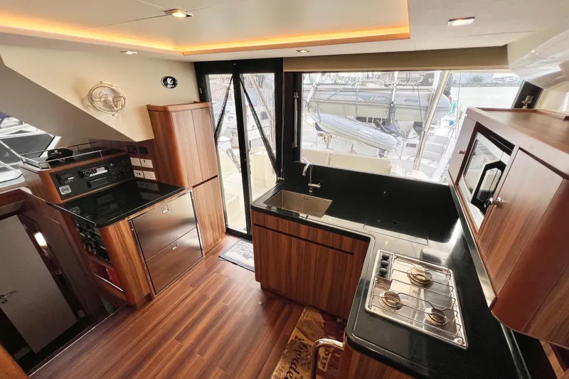 Slide: The Image of Luxurious 2019 Aquila 44 yacht kitchen with modern wood cabinetry and sleek appliances. - 44