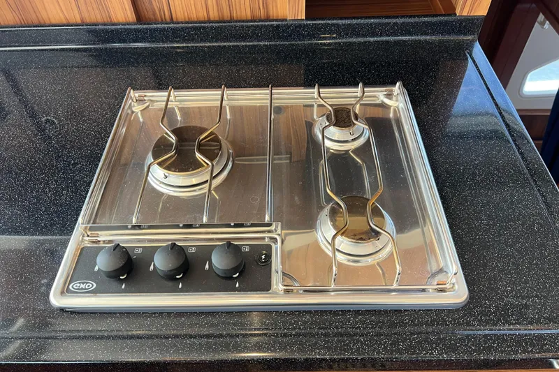 Slide: The Image of Modern gas stove with three burners on a sleek black countertop, Aquila 44, 2019 model. - 50