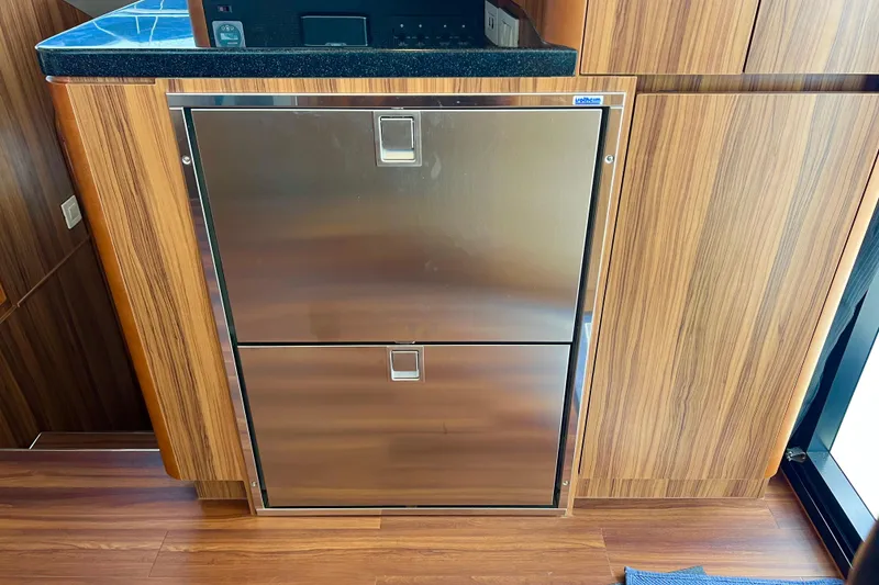 Slide: The Image of Stainless steel refrigerator in 2019 Aquila 44 yacht kitchen with wood paneling. - 52