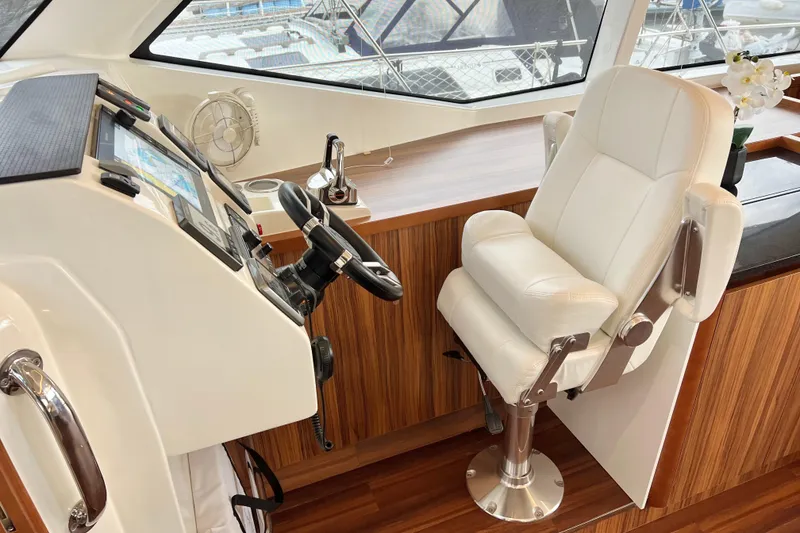 Slide: The Image of Helm station of 2019 Aquila 44 yacht with white captain's chair and navigation controls. - 55