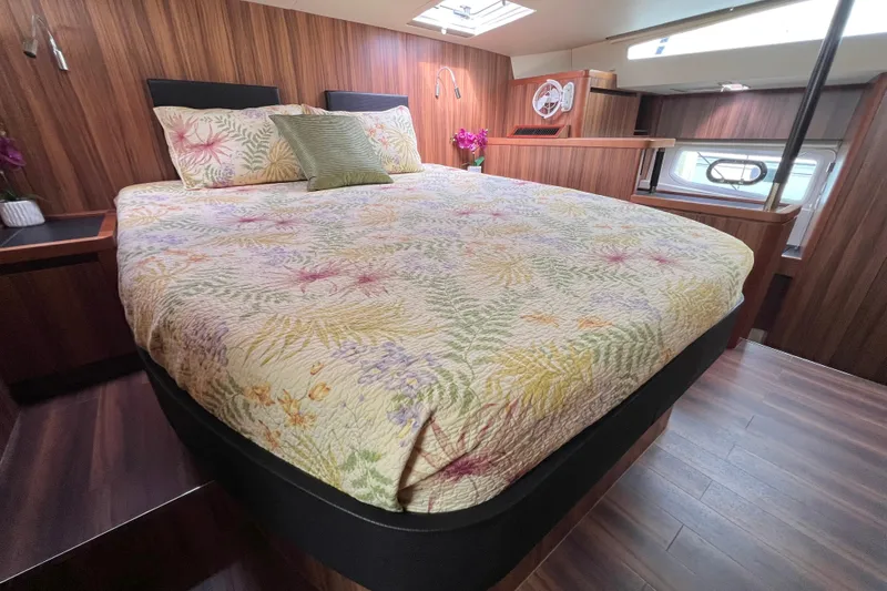Slide: The Image of Luxurious bedroom interior of 2019 Aquila 44 yacht with wood paneling and floral bedding. - 70