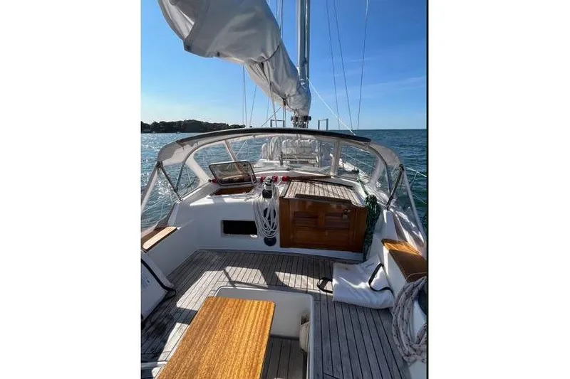 Slide: The Image of 1980 Alden 44 sailboat deck with wooden accents, sailing on a sunny day. - 11