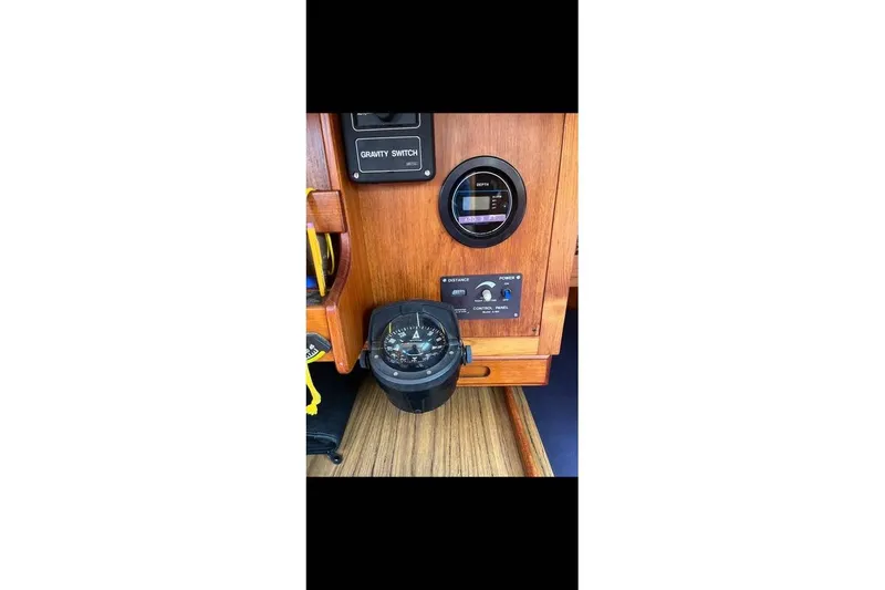 Slide: The Image of 1980 Alden 44 yacht navigation panel with compass and control switches. - 13