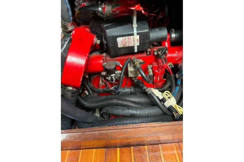 Slide: The Image of Engine compartment of 1980 Alden 44 sailboat, featuring red components and wiring. - 19