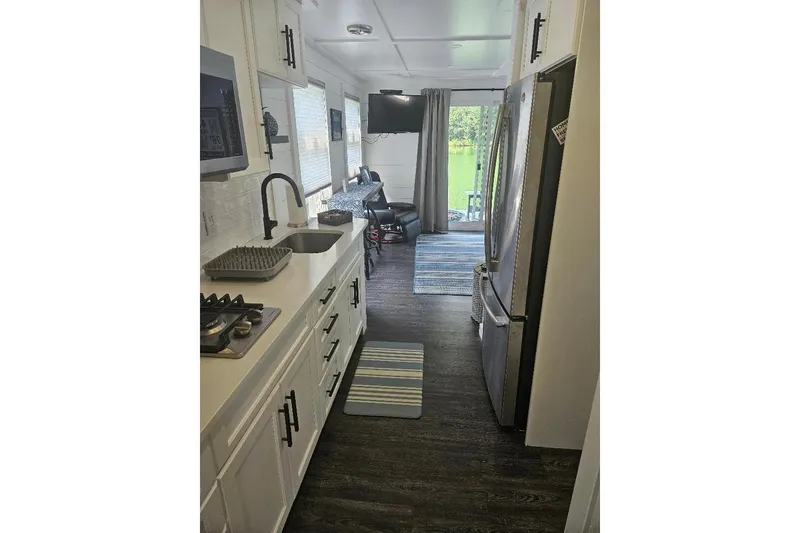 Slide: The Image of Modern kitchen interior of 2021 East Coast Houseboats Freedom 40, featuring sleek appliances and cozy decor. - 12