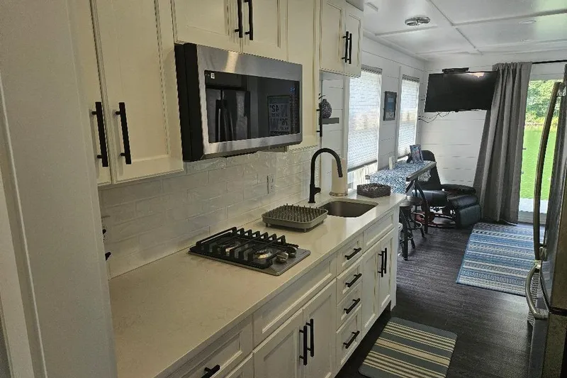 Slide: The Image of Modern kitchen interior of 2021 East Coast Houseboats Freedom 40, featuring sleek appliances and stylish decor. - 14