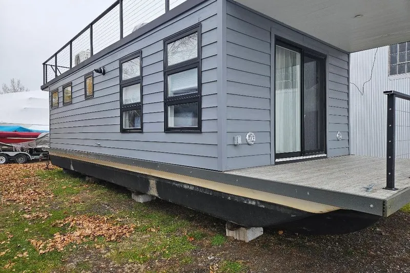 Slide: The Image of Modern 2021 East Coast Houseboats Freedom 40 with sleek gray exterior and large windows. - 21