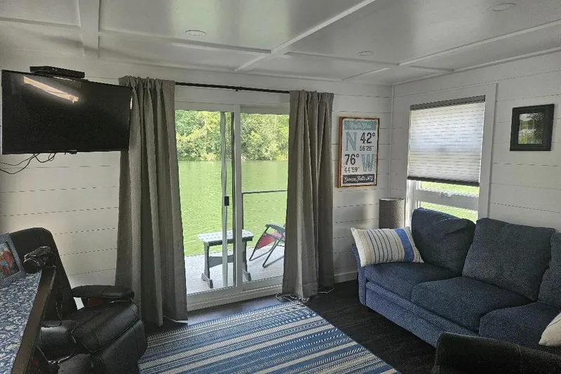 Slide: The Image of Interior of 2021 East Coast Houseboats Freedom 40, featuring cozy seating and scenic water view. - 5