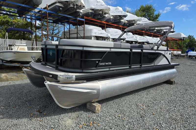 The Image of 2026 Godfrey Sweetwater 2086 C pontoon boat on gravel lot, surrounded by other boats. - 0