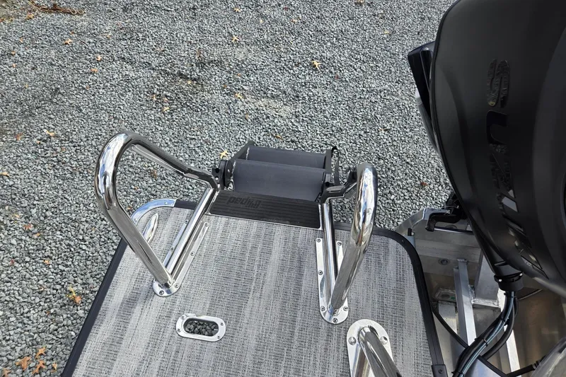 Slide: The Image of 2026 Godfrey Sweetwater 2086 C boat ladder and motor on gravel surface. - 27