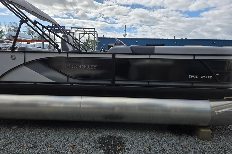 Slide: The Image of 2026 Godfrey Sweetwater 2086 C pontoon boat on gravel lot under cloudy sky. - 6