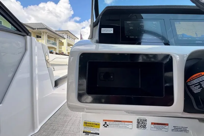 Slide: The Image of 2022 Regal LX2 boat dashboard with digital displays and warning labels. - 10