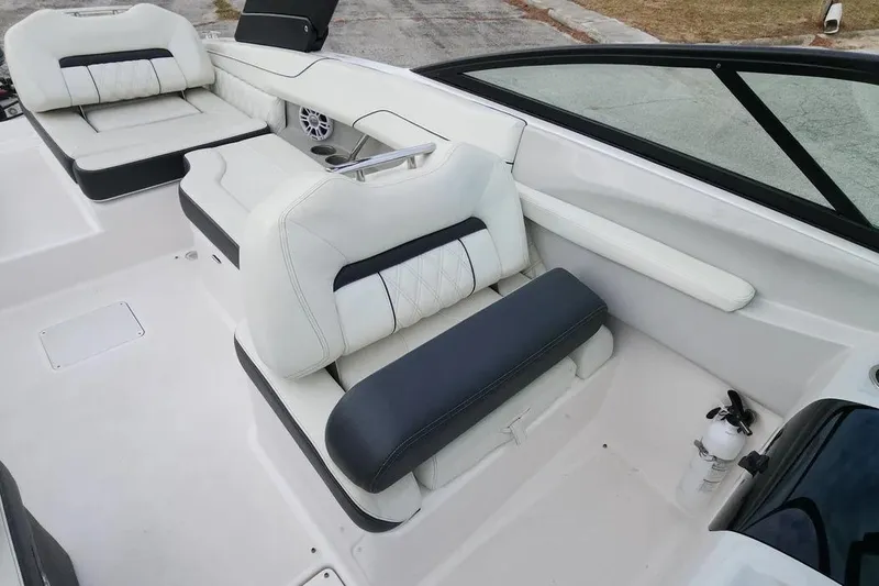 Slide: The Image of 2022 Regal LX2 boat interior with white and black seating, cup holders, and windshield. - 15