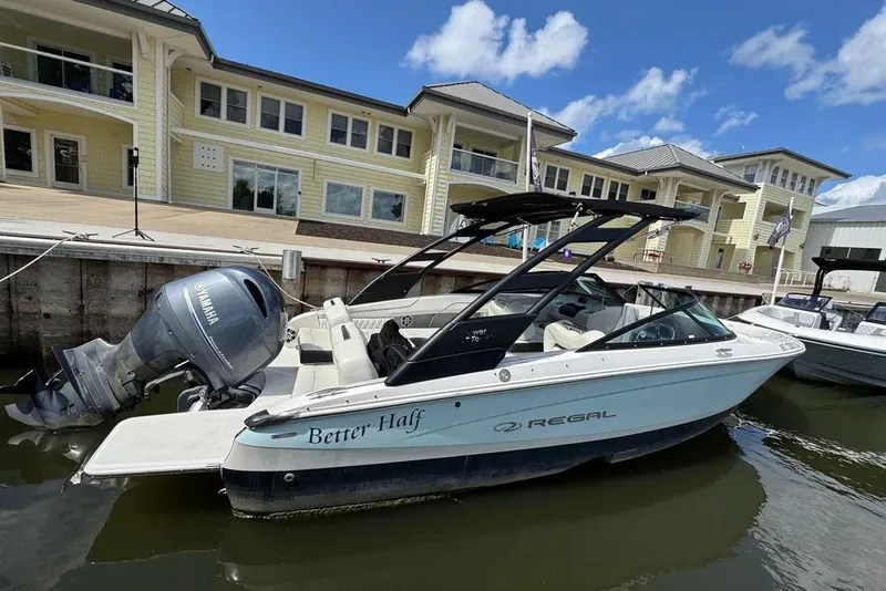 Slide: The Image of 2022 Regal LX2 boat docked by waterfront buildings under a clear blue sky. - 2