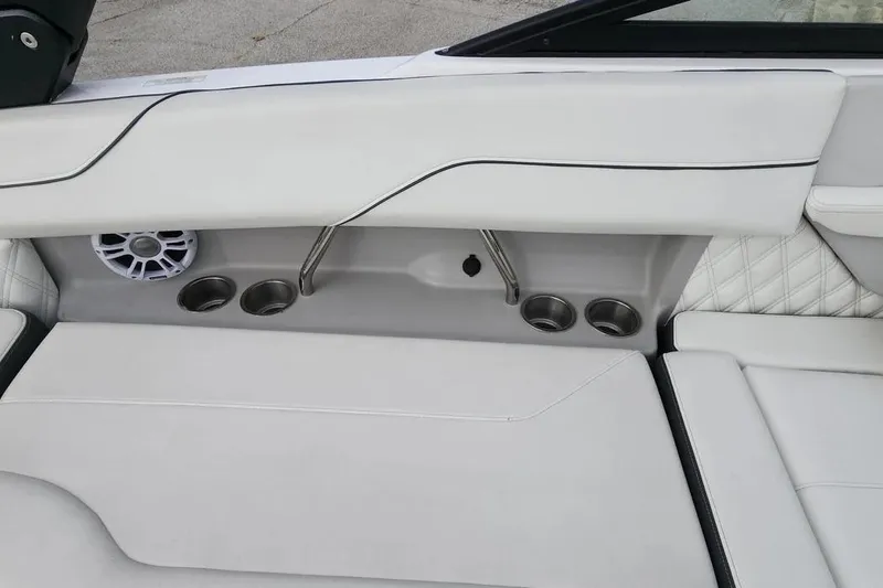 Slide: The Image of 2022 Regal LX2 boat interior with white seating, cup holders, and speaker. - 20