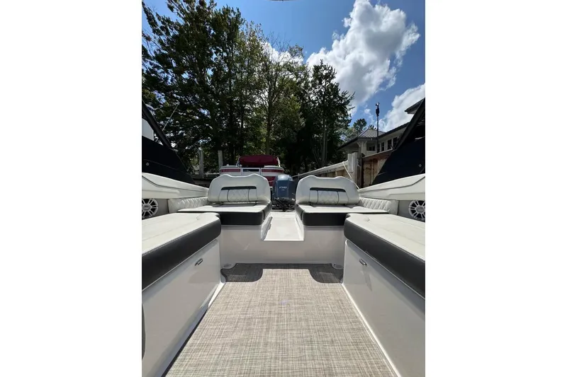 Slide: The Image of 2022 Regal LX2 boat interior with seating, under a clear blue sky. - 22