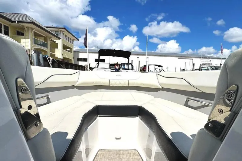 Slide: The Image of 2022 Regal LX2 boat interior with luxurious seating, docked under a bright blue sky. - 25