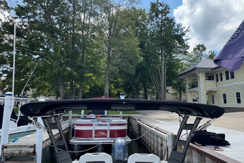 Slide: The Image of 2022 Regal LX2 boat docked near trees and a yellow building under a cloudy sky. - 29