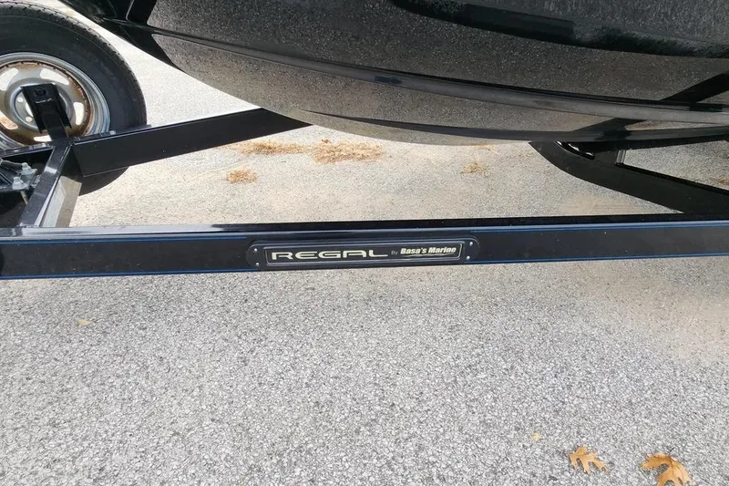 Slide: The Image of 2022 Regal LX2 boat trailer on pavement, showcasing brand logo. - 32