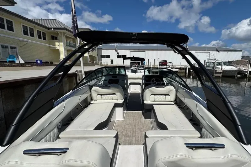 Slide: The Image of 2022 Regal LX2 boat interior with luxurious seating at a marina under a blue sky. - 4