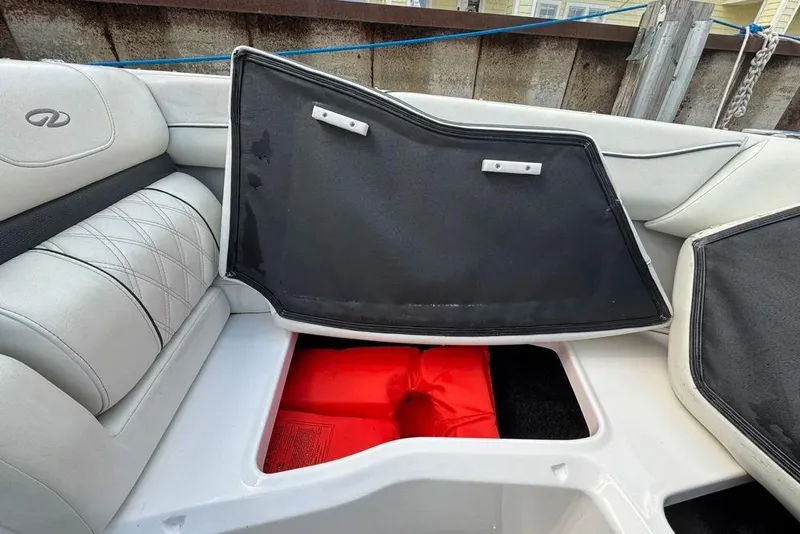 Slide: The Image of 2022 Regal LX2 boat interior with open storage compartment and red life jackets. - 42
