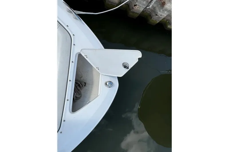 Slide: The Image of 2022 Regal LX2 boat bow with open anchor compartment near dock. - 44