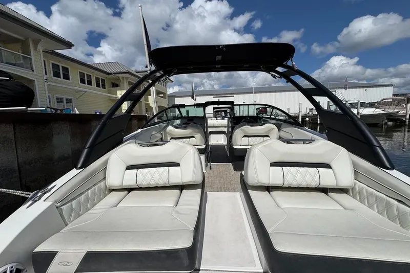 Slide: The Image of 2022 Regal LX2 boat with luxurious seating, docked under a partly cloudy sky. - 48
