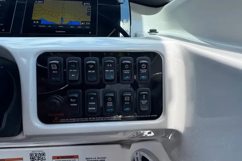 Slide: The Image of Control panel of a 2022 Regal LX2 boat with various switches and a Garmin display. - 9