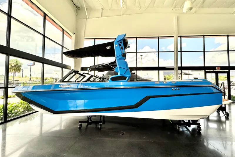 The Image of 2026 Nautique Super Air Nautique GS22, blue boat displayed indoors. - 0