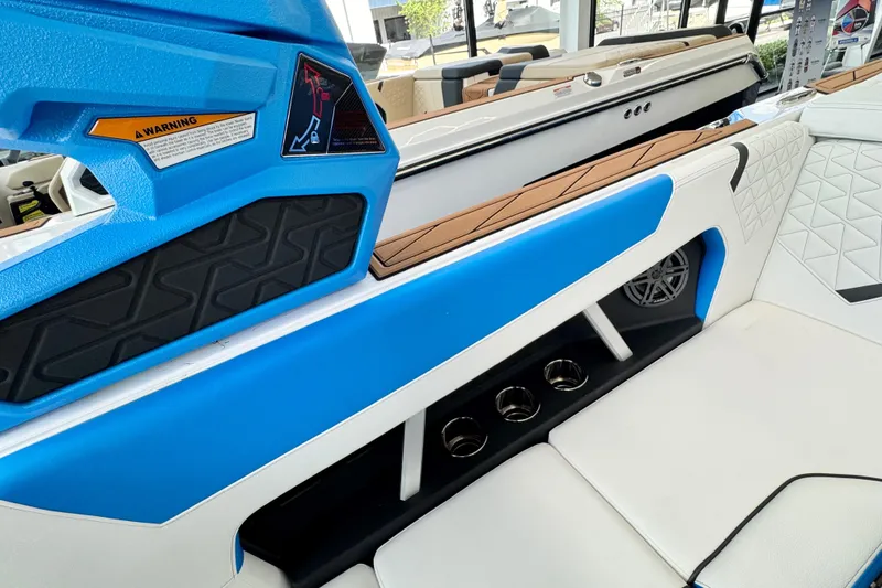 Slide: The Image of 2026 Nautique Super Air Nautique GS22 interior with blue accents and cup holders. - 11