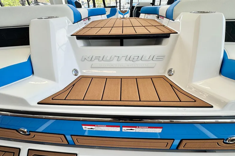 Slide: The Image of 2026 Nautique Super Air Nautique GS22 boat interior with teak flooring and blue accents. - 5