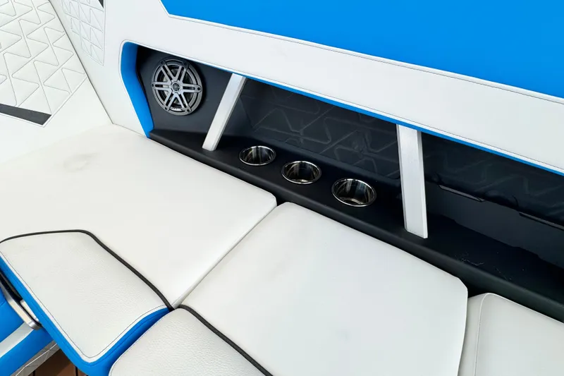 Slide: The Image of 2026 Nautique Super Air Nautique GS22 interior with white seats, cup holders, and speaker. - 7