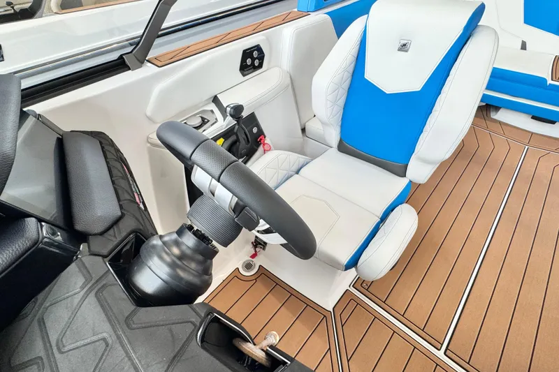 Slide: The Image of 2026 Nautique Super Air Nautique GS22 cockpit with blue and white seating, modern controls, and wood flooring. - 9