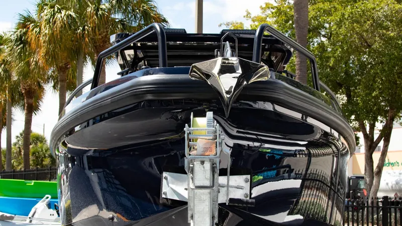 Slide: The Image of 2023 BRABUS Shadow 900 ST boat front view, docked with palm trees in the background. - 2
