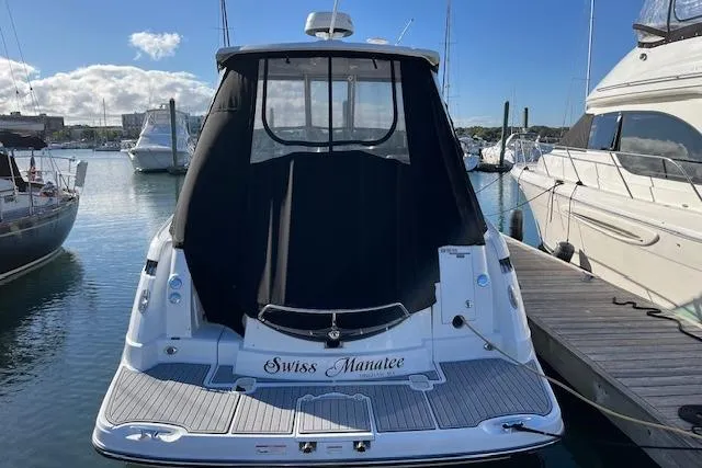 Slide: The Image of 2019 Monterey 355 Sport Yacht docked, rear view with black cover, sunny marina setting. - 2