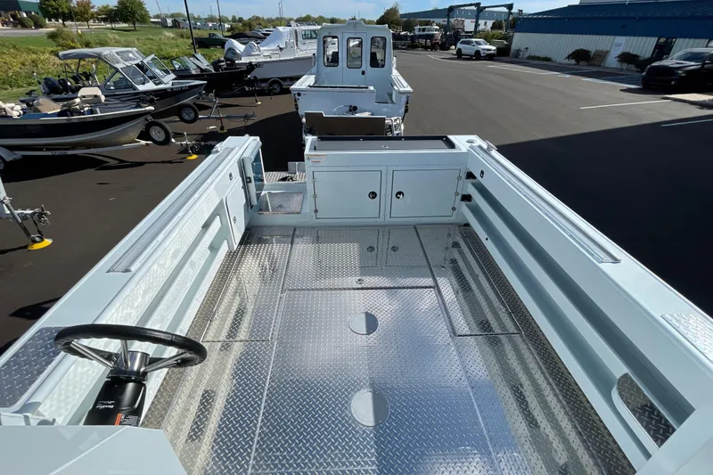 Slide: The Image of 2026 Hewescraft 270 Alaskan ET HT boat with spacious deck and steering wheel, parked outdoors. - 18