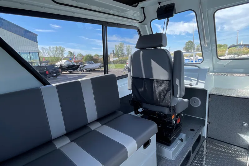 Slide: The Image of Interior of 2026 Hewescraft 270 Alaskan ET HT boat, featuring seating and windows. - 23