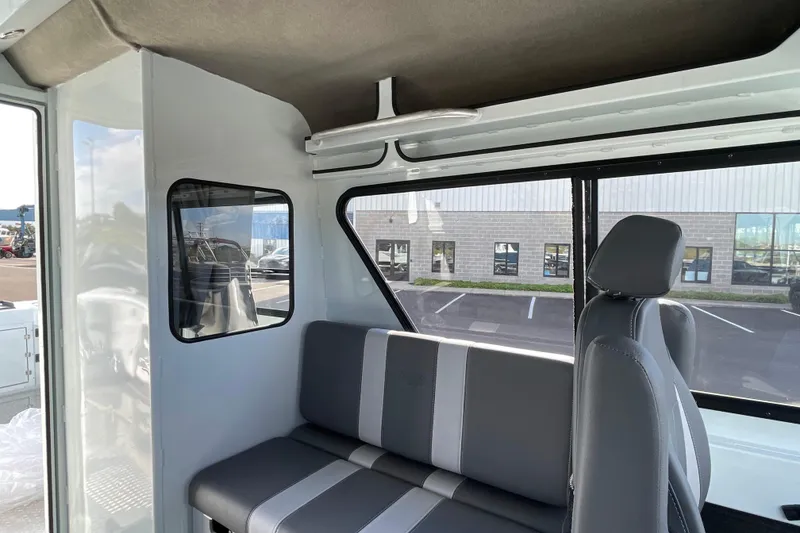 Slide: The Image of Interior of 2026 Hewescraft 270 ALASKAN ET HT boat, featuring gray seating and windows. - 26