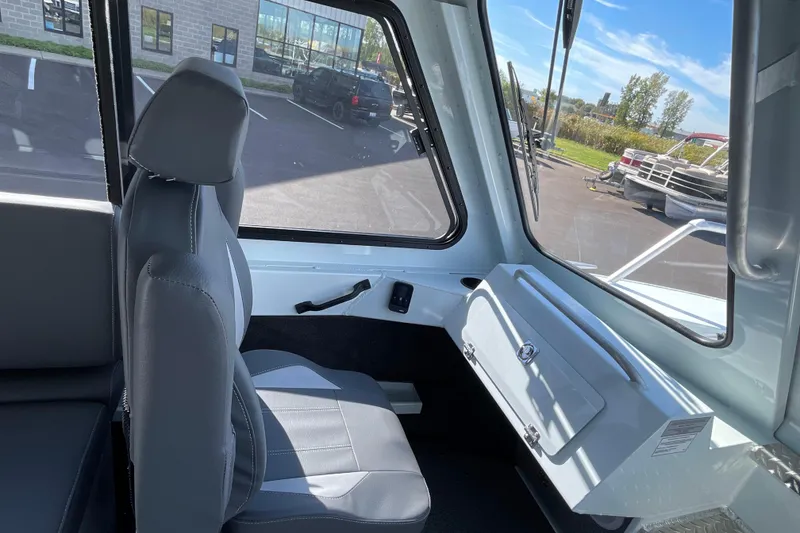 Slide: The Image of 2026 Hewescraft 270 Alaskan ET HT interior with gray seating and large windows. - 31