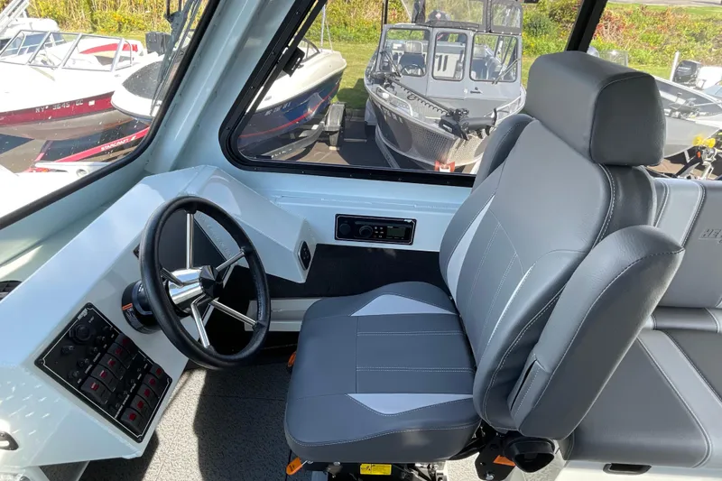 Slide: The Image of 2026 Hewescraft 270 Alaskan ET HT boat interior with steering wheel and captain's chair. - 34