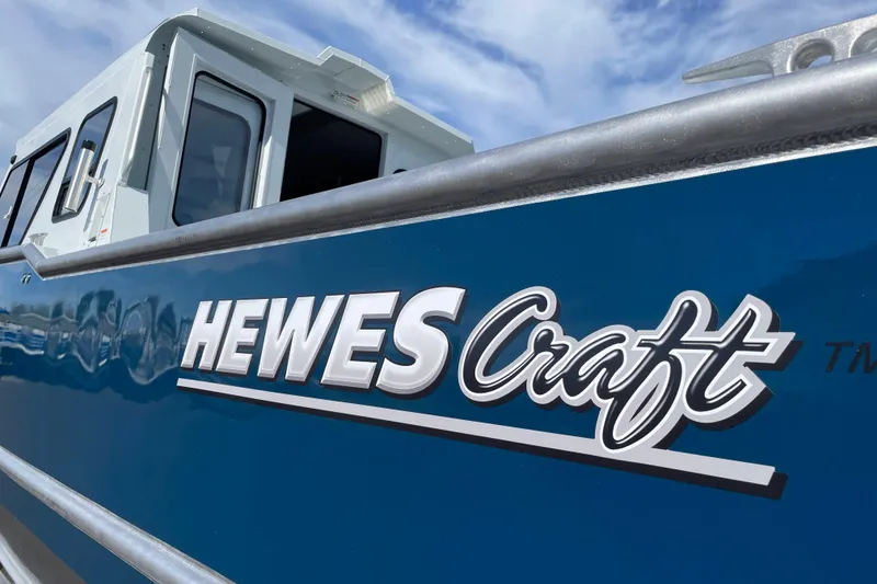 Slide: The Image of 2026 Hewescraft 270 Alaskan ET HT boat with blue exterior and logo. - 42