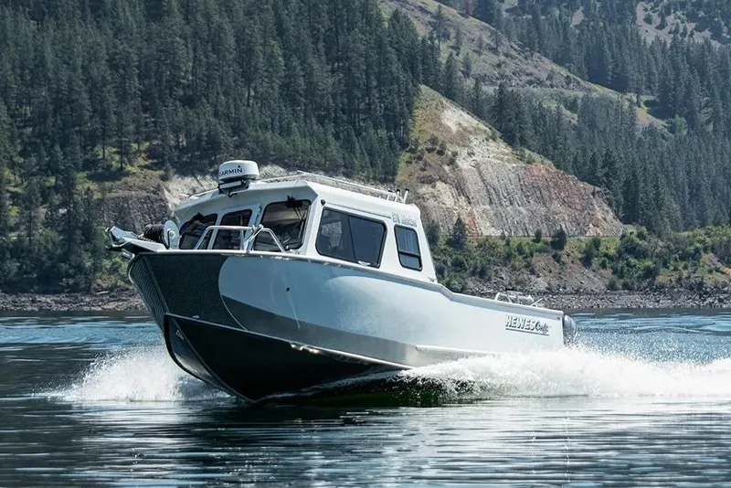 Slide: The Image of 2026 Hewescraft 270 Alaskan ET HT boat cruising on a scenic lake. - 45