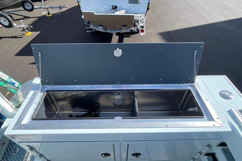 Slide: The Image of 2026 Hewescraft 270 ALASKAN ET HT boat with open storage compartment on deck. - 9