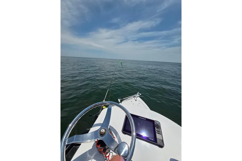 Slide: The Image of 2024 Sea Pro 250 Bay boat on open water, featuring steering wheel and navigation display. - 4