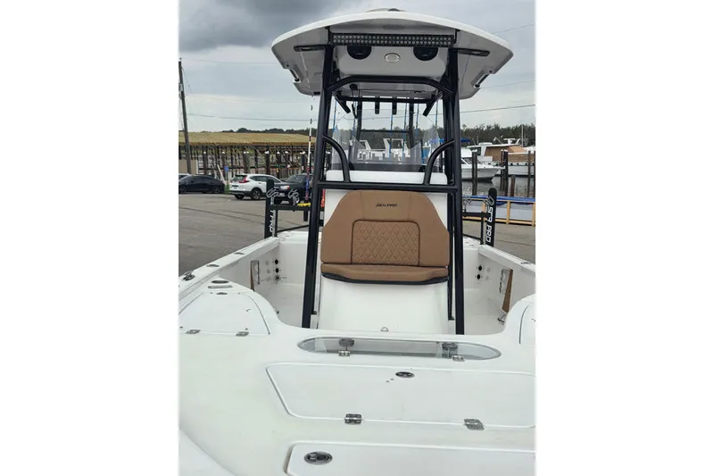 Slide: The Image of 2024 Sea Pro 250 Bay boat with tan seating and T-top, docked at marina. - 5