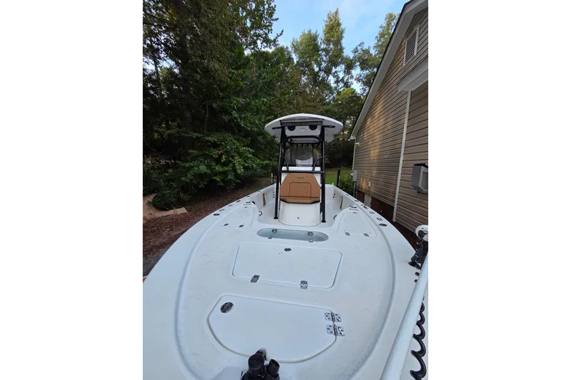 Slide: The Image of 2024 Sea Pro 250 Bay boat docked beside a house, surrounded by trees. - 6