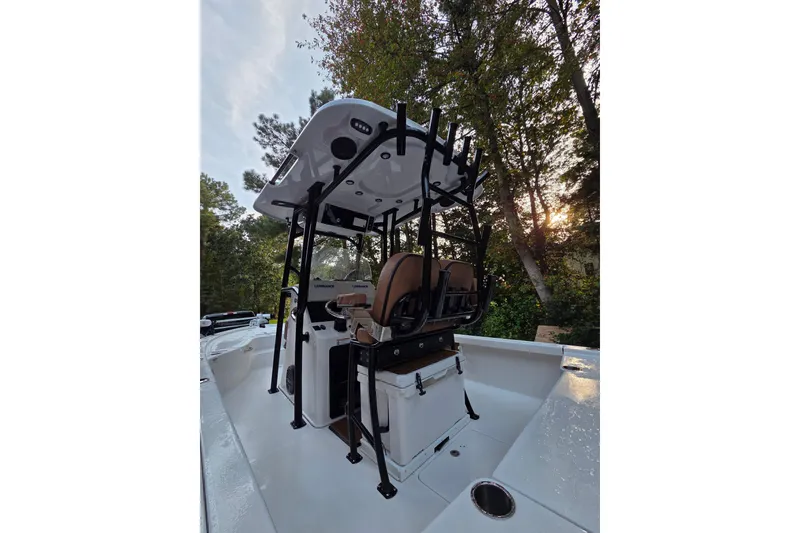 Slide: The Image of 2024 Sea Pro 250 Bay boat with T-top and seating, surrounded by trees. - 8